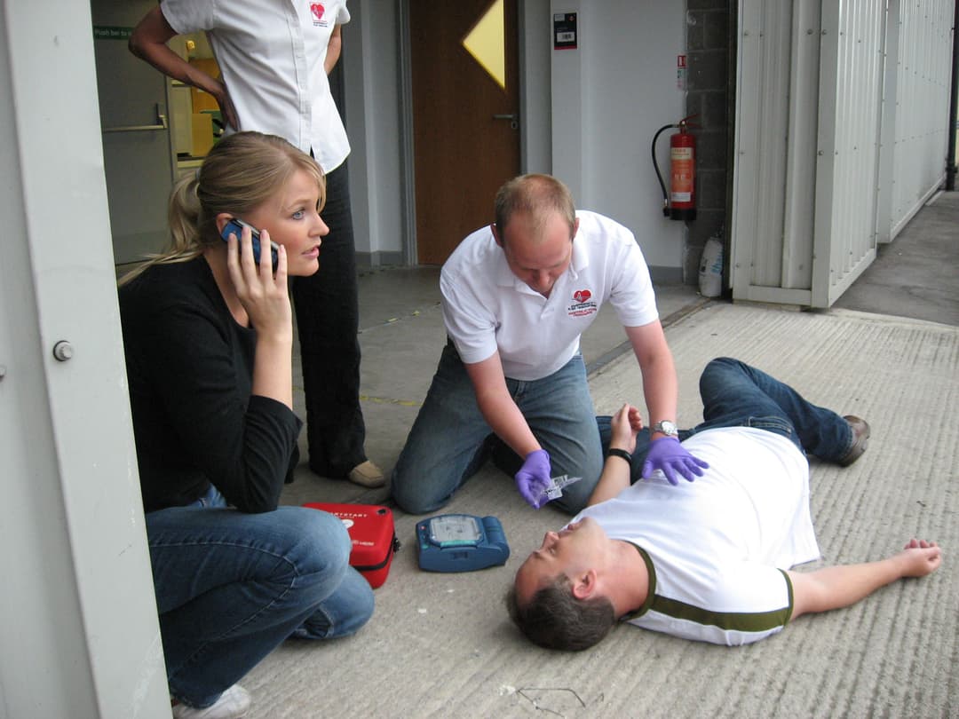First aid team practicing emergency response with an AED