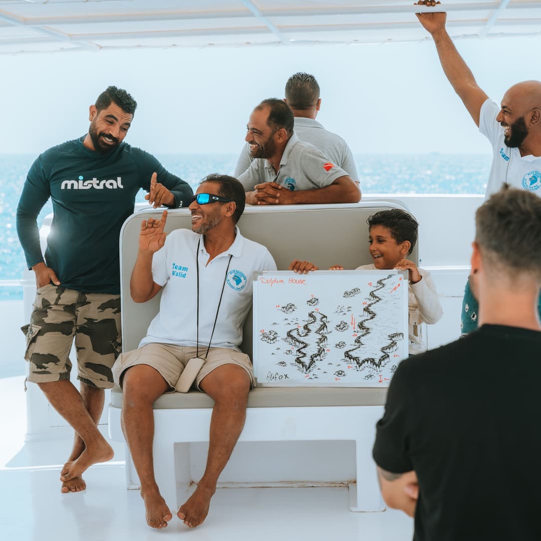 Divemaster training group reviewing a dive site map on board