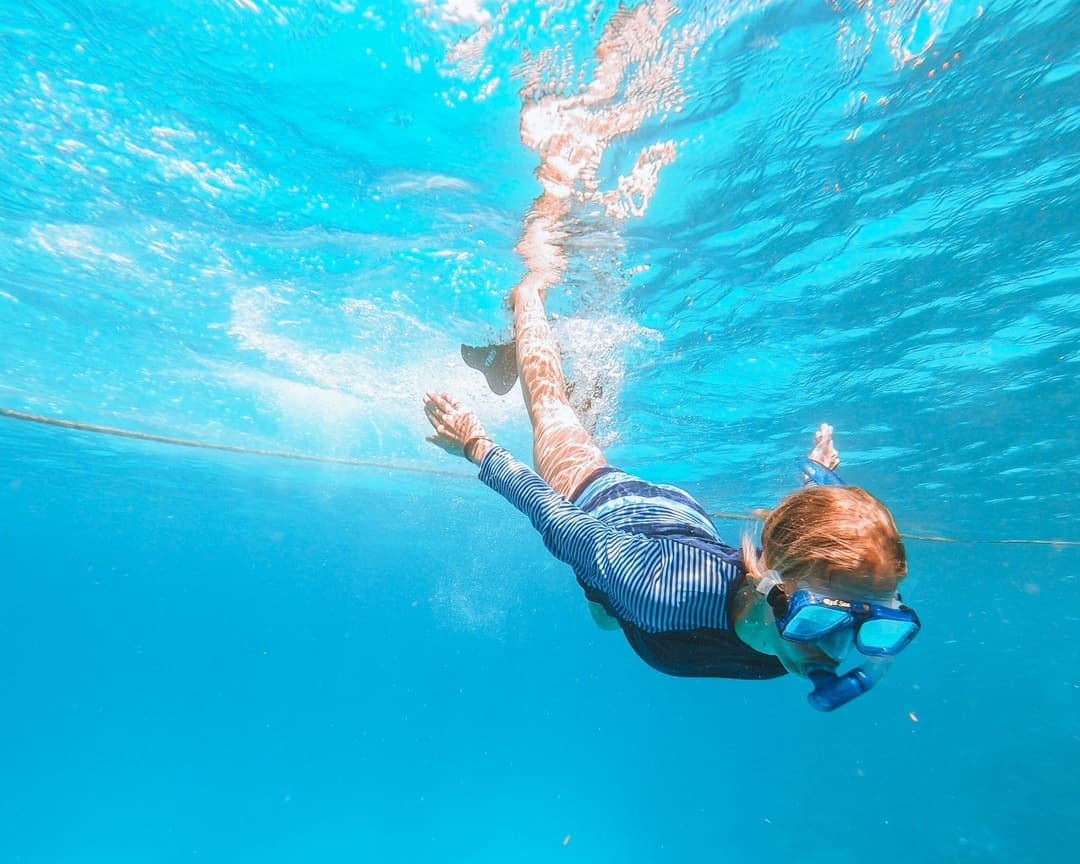 Child snorkeling in clear Red Sea water